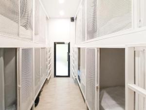 a corridor of a prison cell with white shelves at Paknap Hostel in Nan