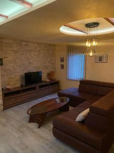 een woonkamer met een bank en een tv bij Motel pizzeria Antic's in Laktaši