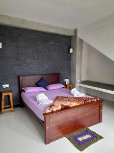 Water Side Guest في نالاثانيا: غرفة نوم مع سرير مع ملاءات أرجوانية ومخدات أرجوانية