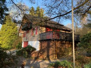 una casa con un balcón en el lateral. en Gezellige familie chalet, en Oizy