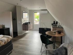 a room with a kitchen and a table and a room with a bed at Torenzicht in Kapelle