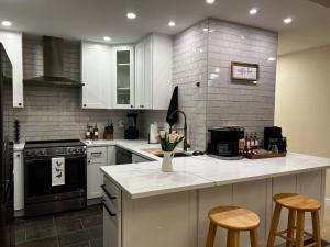 a kitchen with white cabinets and a counter with stools at Luxury Condo-Downtown Bellevue in Bellevue