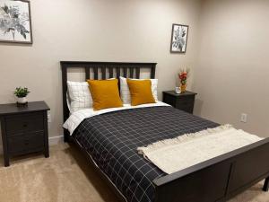 ein Schlafzimmer mit einem Bett mit gelben Kissen und 2 Tischen in der Unterkunft Luxury Condo-Downtown Bellevue in Bellevue