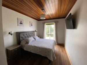 a bedroom with a bed and a television and a window at AH Rent in Quintero