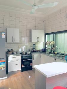 cocina con armarios blancos y fogones en Superbe maison dans un quartier calme - Bénin, en Ekpé