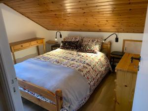 - une chambre avec un lit et un plafond en bois dans l'établissement Gezellige familie chalet, à Oizy