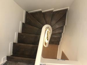 una escalera de caracol en una casa con una escalera de madera en La plus petite maison de pêcheur de Trouville-sur-mer, en Trouville-sur-Mer