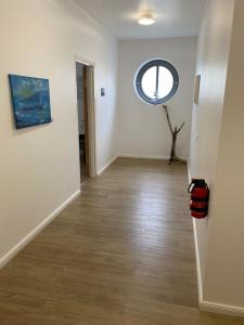 un pasillo con una ventana redonda en una habitación blanca en Gästehaus Lavendel, en Flensburg