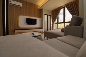 a hotel room with a bed and a couch and a tv at Mykey Bali B-07-01 Melaka City in Melaka