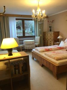 a hotel room with two beds and a chandelier at Alpbach Apartments in Reith im Alpbachtal