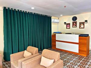 a living room with a green curtain and two chairs at دريم العليا للوحدات السكنية in Al Khobar
