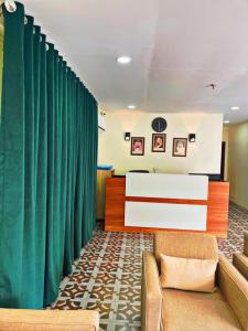 sala de estar con cortina verde y sofá en دريم العليا للوحدات السكنية en Al Khobar