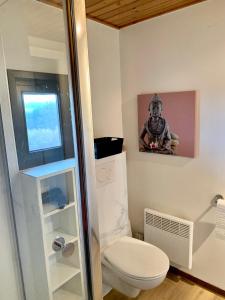 uma casa de banho com WC e uma fotografia na parede em Gezellige familie chalet em Oizy