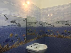a bathroom with a sink and a fish mural on the wall at Jilan Homestay in Bentota