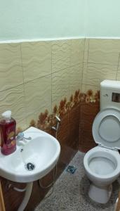 a bathroom with a white toilet and a sink at WK HOMESTAY PASIR MAS in Pasir Mas