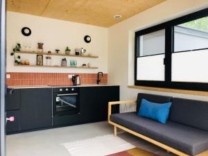 a living room with a couch and a kitchen at New relaxing mountain getaway. in Döllach