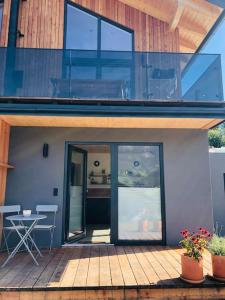 a house with glass doors and a table on a deck at New relaxing mountain getaway. in Döllach +8 photos