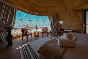 una camera da letto con un letto e vista sull'oceano di Siniya Island Leisure Campground Umm Al Quwain a Umm Al Quwain Altre 37 foto