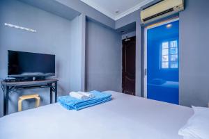 a bedroom with a white bed with a tv and a bed sidx sidx at K Hotel 14 in Singapore