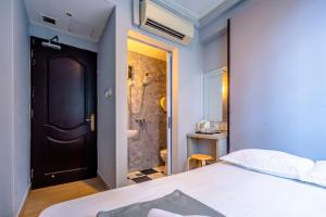 1 dormitorio con 1 cama y baño con ducha en K Hotel 14, en Singapur
