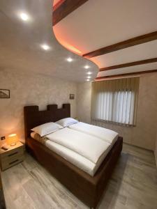 1 dormitorio con 1 cama grande en una habitación en Motel pizzeria Antic's en Laktaši