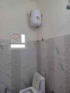 a bathroom with a white toilet and a box on the wall at HOTEL SANGAM GARDEN in Girīdīh