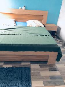 a bed with a wooden headboard in a bedroom at Superbe maison dans un quartier calme - Bénin in Ekpé