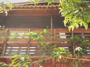 une maison en bois avec des arbres devant elle dans l'établissement เฮือนน่านนิทรา, à Nan