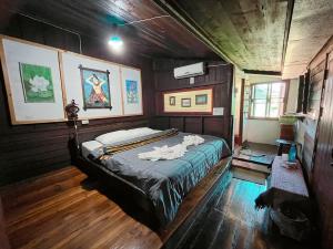 - une chambre avec un lit dans une pièce en bois dans l'établissement เฮือนน่านนิทรา, à Nan