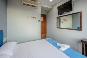 a bedroom with a bed with a mirror and a tv at K Hotel 1515 in Singapore