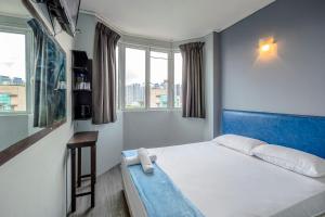 1 dormitorio con 1 cama y 2 ventanas en K Hotel 1515, en Singapur
