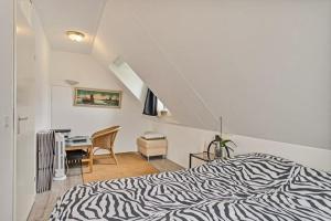 Schlafzimmer mit einem Zebra-Bett und einem Schreibtisch in der Unterkunft Mooie twee-onder-een-kapwoning te Vlagtwedde in Vlagtwedde