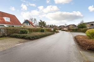 Une route vide dans un quartier résidentiel avec des maisons dans l'établissement Mooie twee-onder-een-kapwoning te Vlagtwedde, à Vlagtwedde