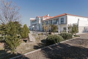 um edifício com um jardim em frente em Hotel Estrela Da Idanha em Idanha-a-Nova