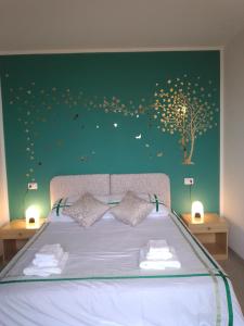a bedroom with a bed with a tree on the wall at Hotel Riposo in Gatteo a Mare