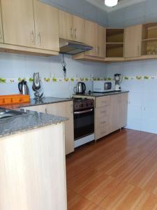 a kitchen with white cabinets and a stove top oven at SERENITAS ApartHotel in Kigali