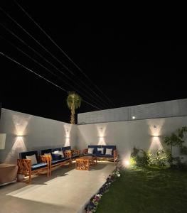 un patio con sofás y mesas por la noche en شاليه الماسيه خاص و مميز بأحدث المواصفات لنصنع الجمال بعينه, en Riad