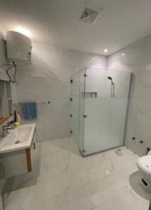 a white bathroom with a shower and a sink at شاليه الماسيه خاص و مميز بأحدث المواصفات لنصنع الجمال بعينه in Riyadh