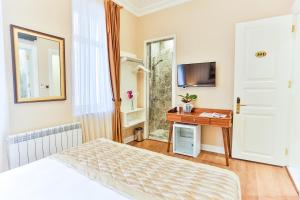 a bedroom with a bed and a desk and a television at HANENDE HOTEL in Istanbul
