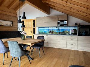 a dining room with a wooden table and chairs at Wally Luxus Lodge im Ferienhaus Magdalena in Mittenwald +12 photos