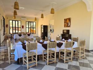 una sala da pranzo con un lungo tavolo e sedie di Le Domaine M a Ouzoud