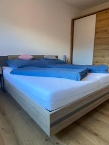 a bedroom with a large bed with blue pillows at Leonies Appartement in Sautens