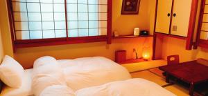 una camera con un letto bianco e una finestra di Nara Ryokan a Nara