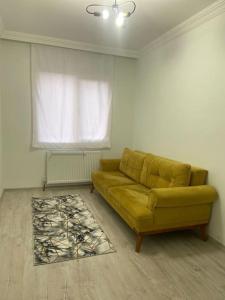 sala de estar con sofá amarillo y ventana en 2bedroom cozy apartment en Estambul