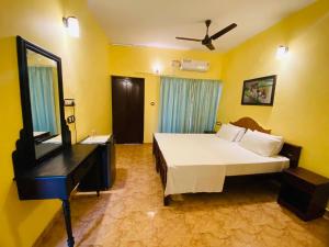 een slaapkamer met een bed, een dressoir en een spiegel bij Karma Beach Resort in Kovalam