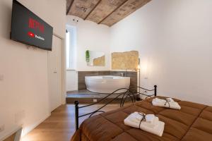 ein Schlafzimmer mit einer Badewanne und einem Bett mit Handtüchern in der Unterkunft L'Antica Voltina in Nettuno