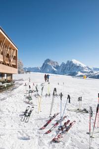 eine Gruppe von Skiern und Skistöcken im Schnee in der Unterkunft ICARO Hotel in Alpe di Siusi