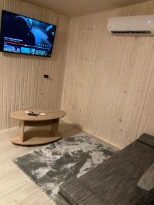um quarto com uma mesa e uma televisão na parede em MilAdrija em Rokiskis