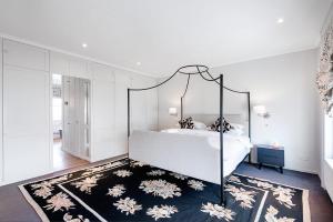 a bedroom with a canopy bed and a rug at The Notting Hill Townhouse in London