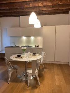 cocina con mesa y sillas en una habitación en Appartamento C'est la vie in barchessa Veneta, en Fiesso dʼArtico